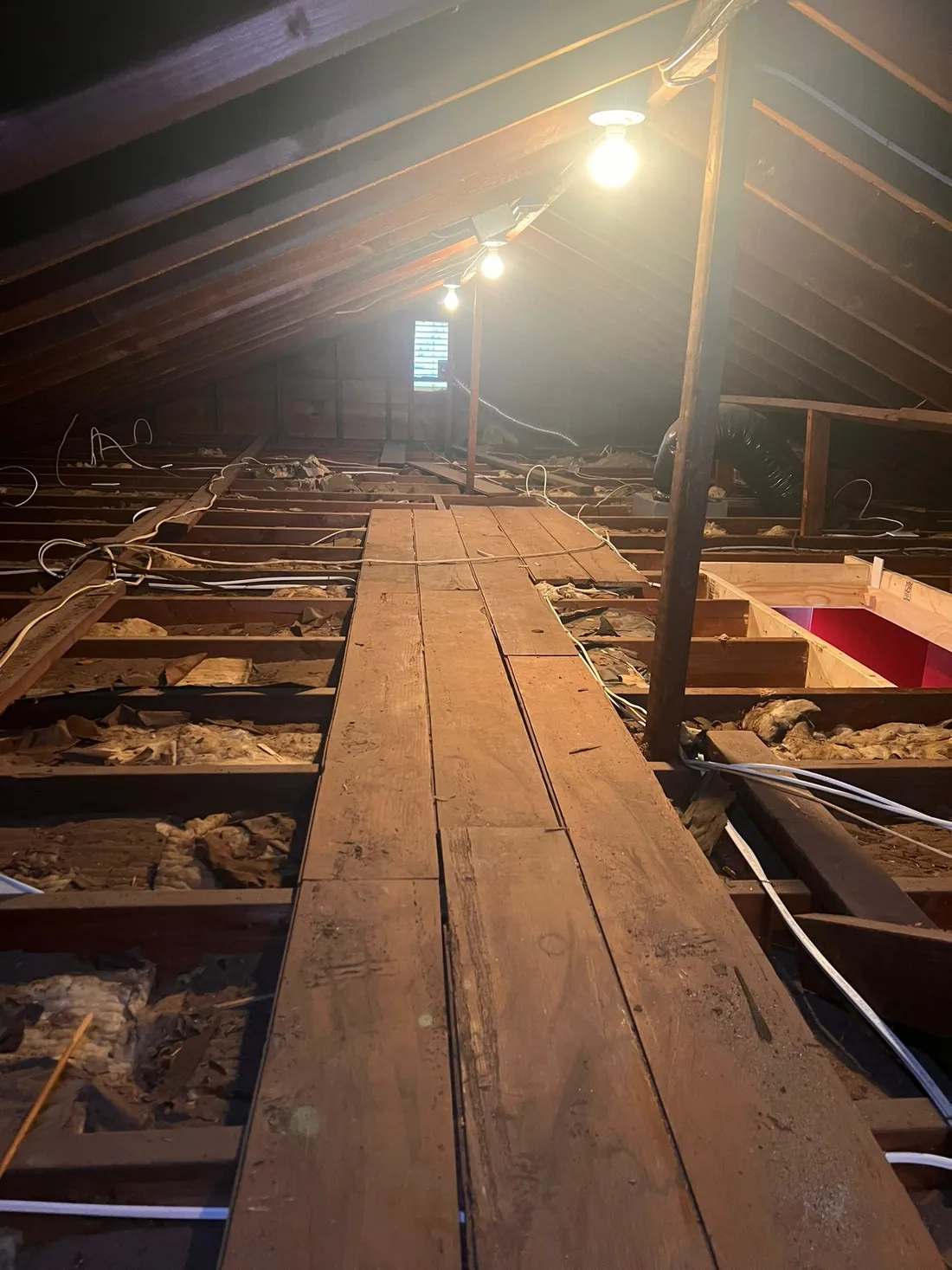 An attic before Master Attic service, old batts over exposed joists