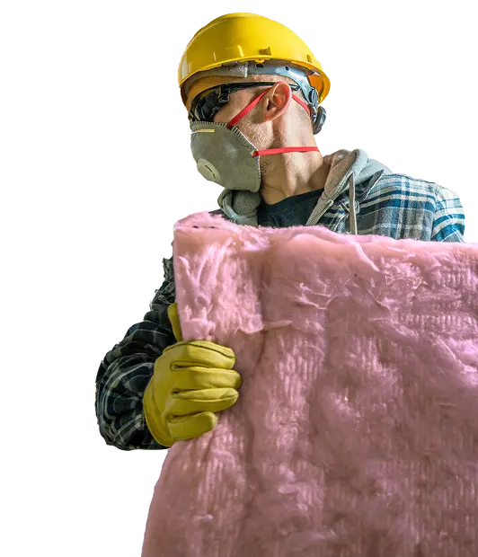 Insulation installer with safety gear applying pink attic insulation for commercial building upgrade.