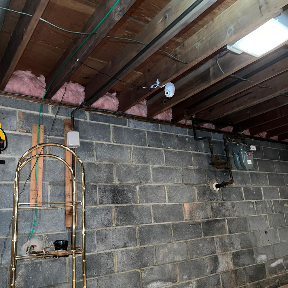 Image of a refurbished basement following the installation of mineral wool and new wood beams